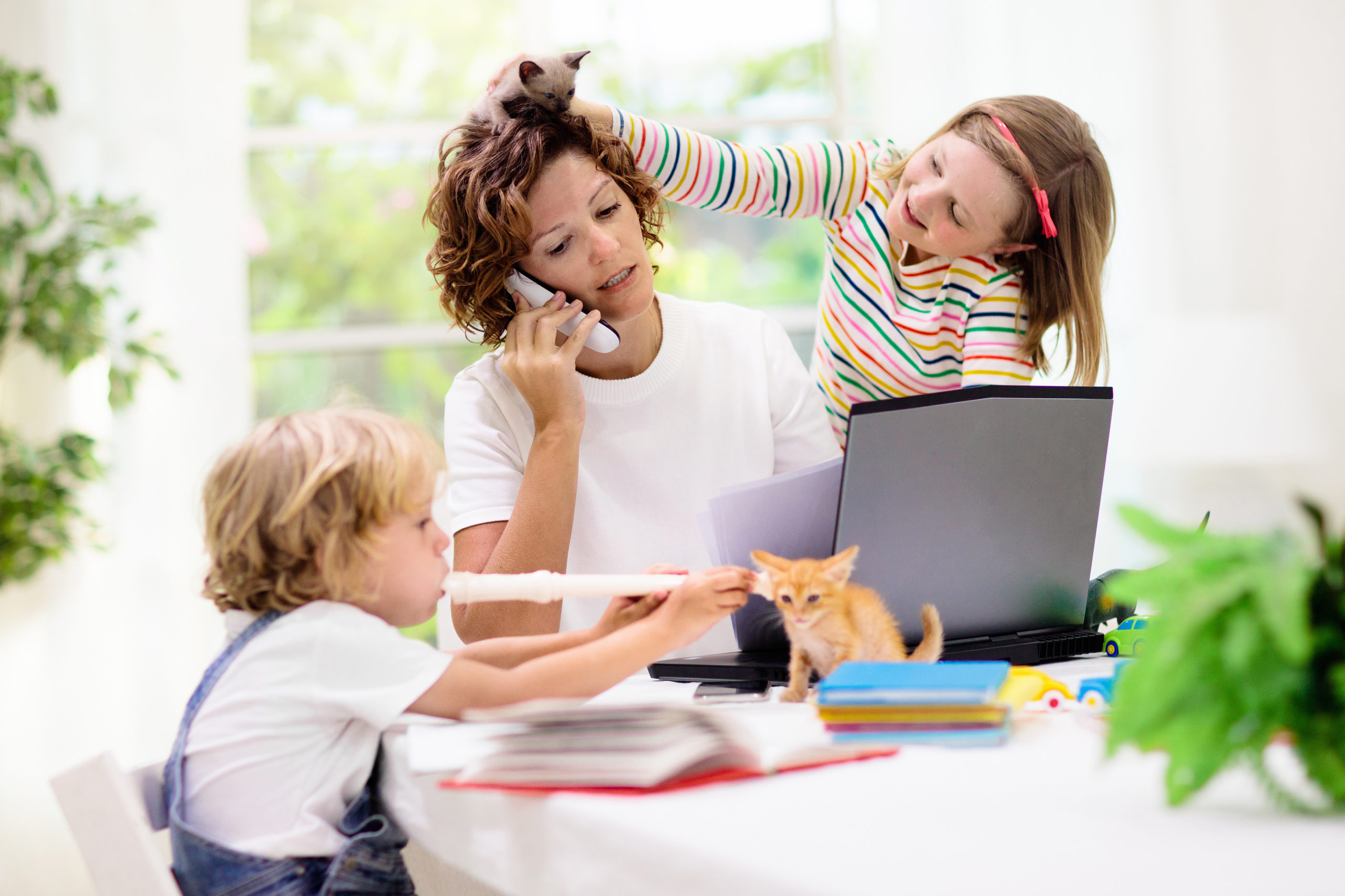 Mother working from home with kids. Quarantine and closed school during coronavirus outbreak. Children make noise and disturb woman at work. Homeschooling and freelance job. Boy and girl playing.